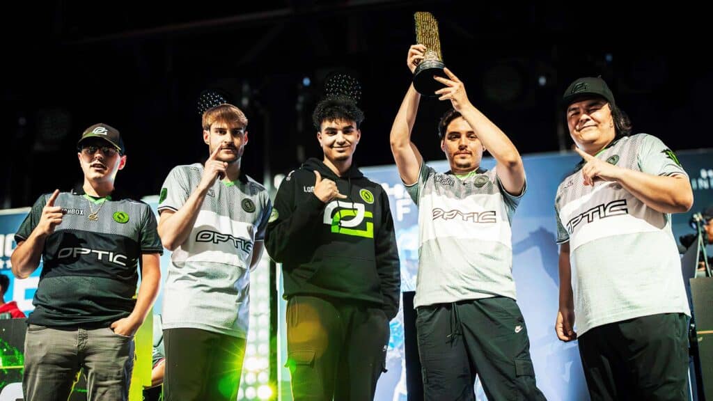 Image of OpTic Gaming Halo team celebrating victory on stage. One of the players is holding a small golden trophy